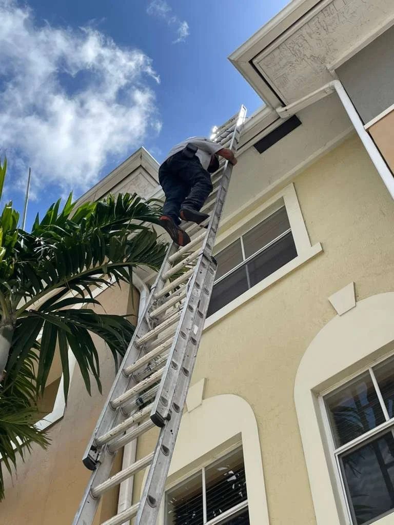 Miembro del equipo de Skymen Roofing subiendo una escalera para inspeccionar un techo